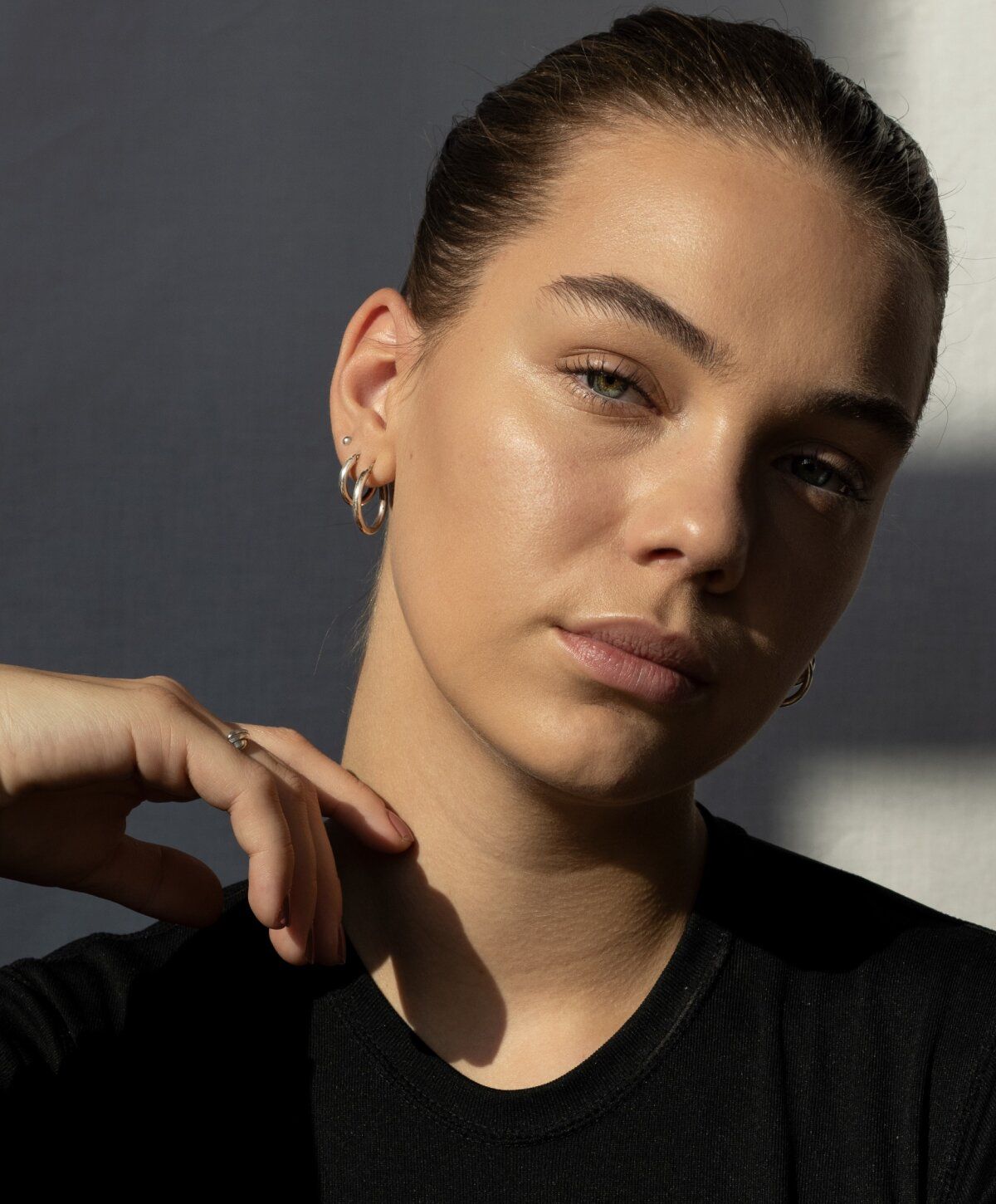 Model with earrings and natural makeup.